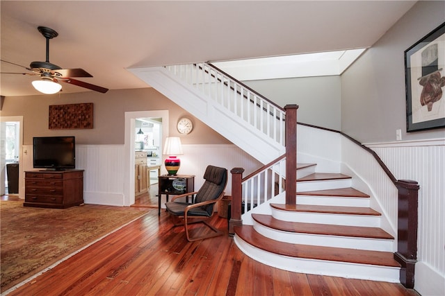 staircase with hardwood / wood-style flooring and ceiling fan