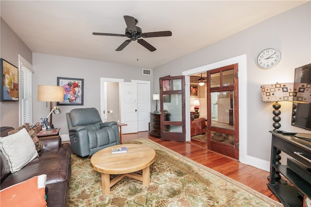 living room with hardwood / wood-style flooring and ceiling fan