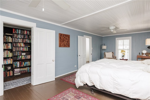 bedroom featuring dark hardwood / wood-style flooring, ceiling fan, and crown molding