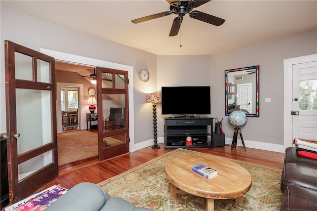 living room with french doors, a wealth of natural light, wood-type flooring, and ceiling fan