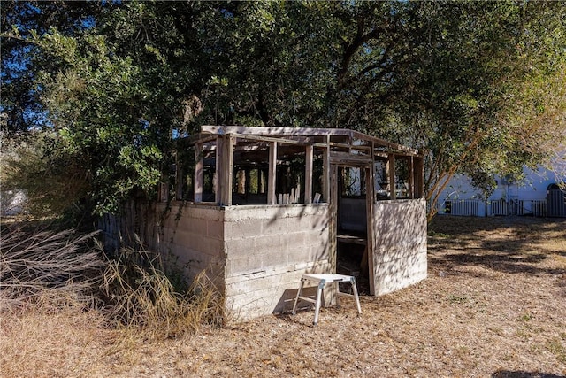 view of outdoor structure featuring fence and an outdoor structure