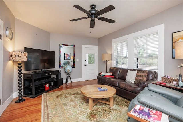 living area with light wood-style floors, ceiling fan, and baseboards