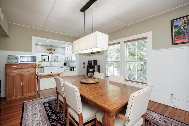 dining space with wainscoting and wood finished floors