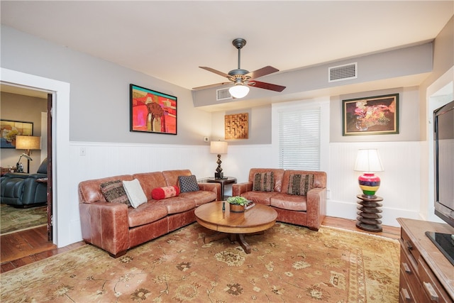 living room featuring wood-type flooring and ceiling fan