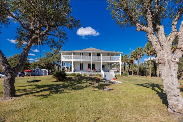 back of property with covered porch, a lawn, and a balcony