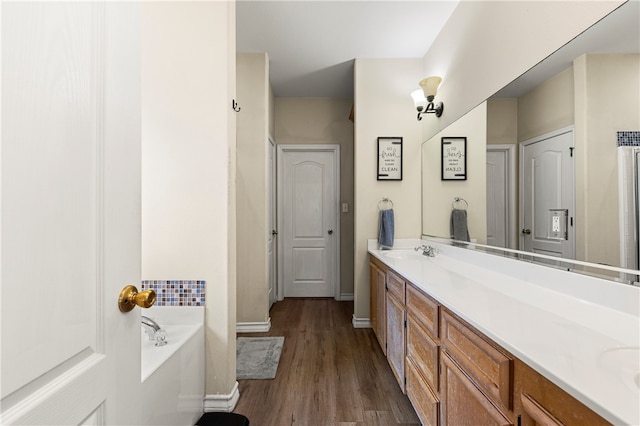 bathroom featuring hardwood / wood-style flooring, vanity, and a bath