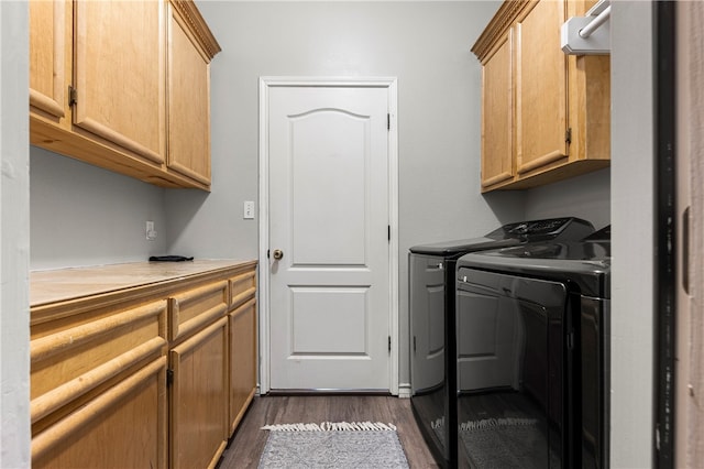 washroom featuring separate washer and dryer, dark hardwood / wood-style floors, and cabinets