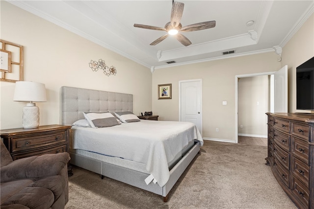 carpeted bedroom with a raised ceiling, ceiling fan, and crown molding