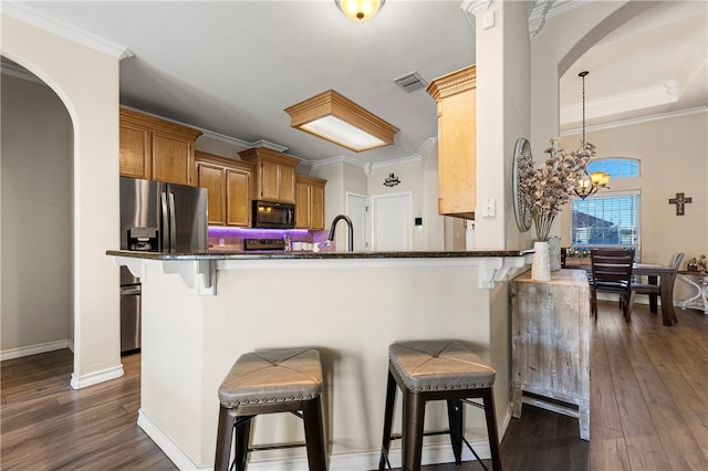 kitchen with kitchen peninsula, pendant lighting, a chandelier, dark hardwood / wood-style floors, and a breakfast bar area