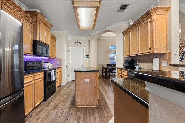 kitchen with decorative backsplash, hardwood / wood-style floors, crown molding, and black appliances