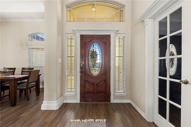 foyer entrance with dark hardwood / wood-style floors and ornamental molding