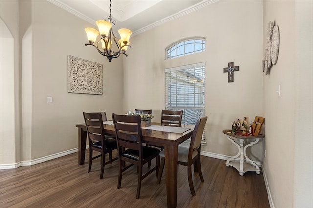 dining space with dark hardwood / wood-style flooring, ornamental molding, and an inviting chandelier