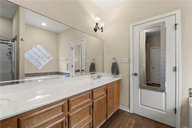 bathroom with a shower, hardwood / wood-style floors, and vanity