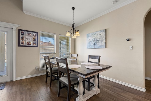 dining room featuring dark hardwood / wood-style flooring, ornamental molding, and a chandelier