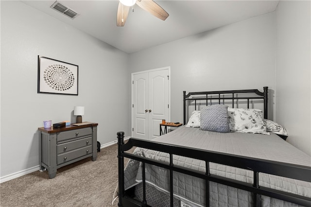 bedroom with ceiling fan, light colored carpet, and a closet