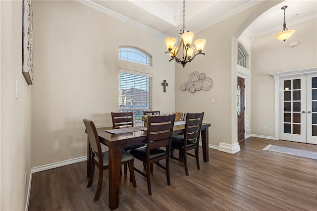 dining area featuring crown molding, dark hardwood / wood-style flooring, french doors, and an inviting chandelier