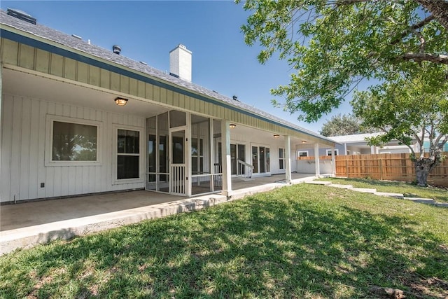 back of property featuring a patio area, a chimney, and a sunroom