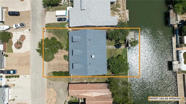 aerial view of property and surrounding area with property parcel outlined and a nearby body of water