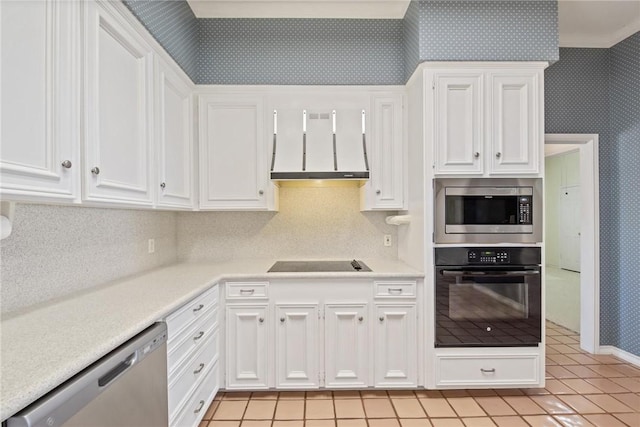 kitchen with black appliances, premium range hood, wallpapered walls, white cabinetry, and light countertops