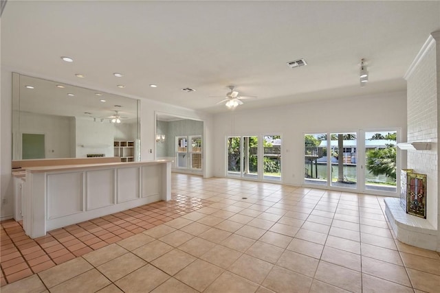 unfurnished living room with ceiling fan, light tile patterned floors, recessed lighting, and a water view