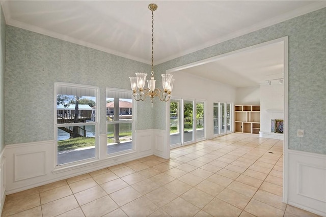 unfurnished dining area featuring wainscoting, a chandelier, a decorative wall, wallpapered walls, and tile patterned flooring