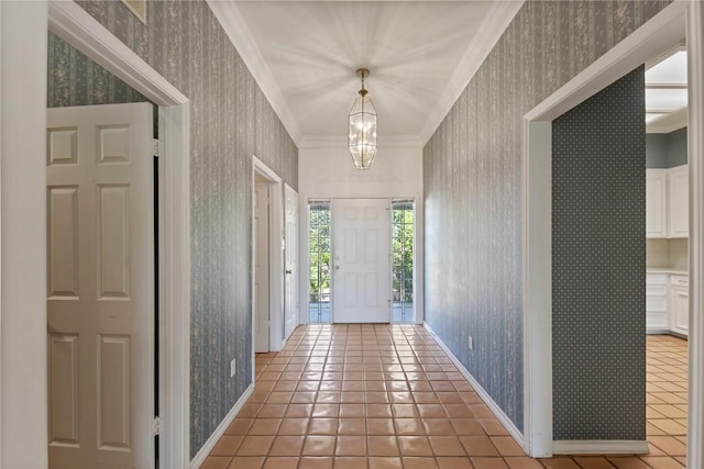 foyer featuring wallpapered walls, light tile patterned floors, a chandelier, baseboards, and crown molding