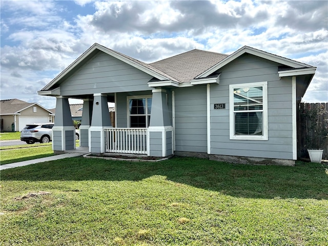 view of front of property with a porch, a front yard, and a garage