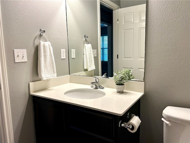 bathroom featuring vanity and toilet