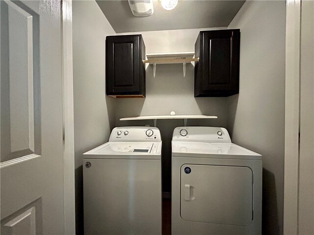 laundry room with separate washer and dryer and cabinets