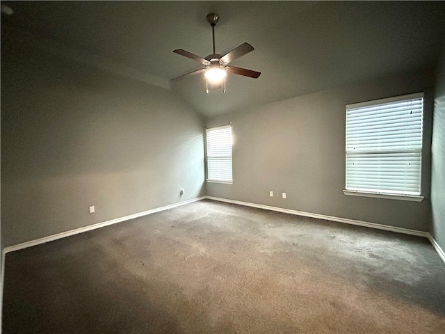 empty room with vaulted ceiling, carpet flooring, and ceiling fan