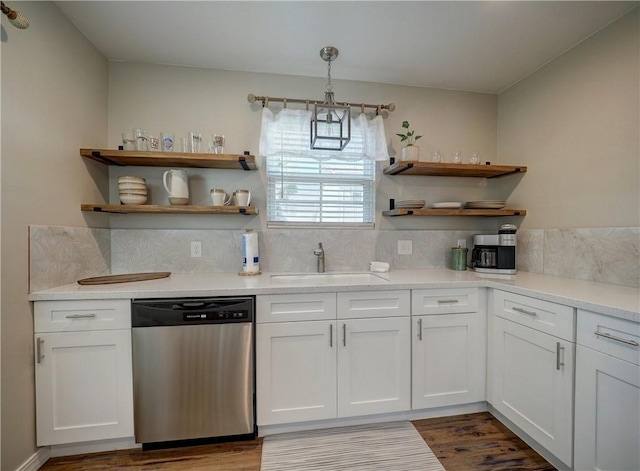 kitchen with pendant lighting, tasteful backsplash, sink, white cabinets, and stainless steel dishwasher