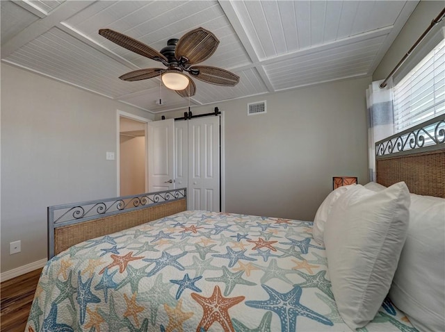 bedroom with wood ceiling, ceiling fan, a barn door, and dark hardwood / wood-style flooring