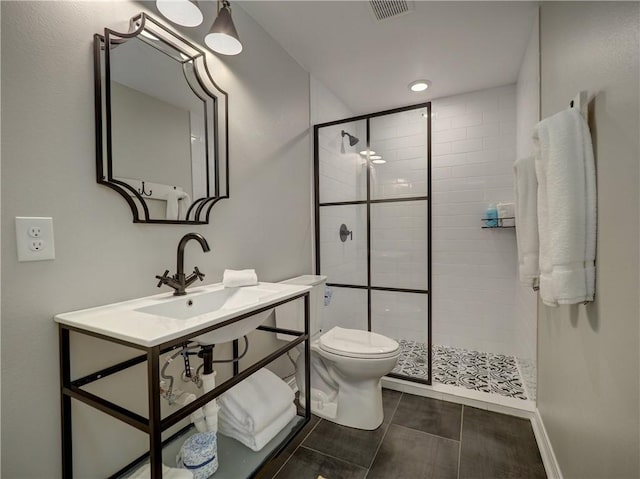 bathroom featuring sink, toilet, and a shower with door