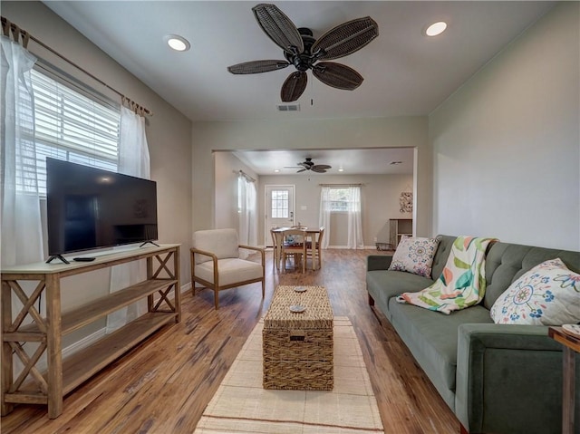 living room with wood-type flooring and ceiling fan