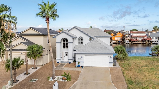 view of front of property featuring a garage, a water view, and a front lawn