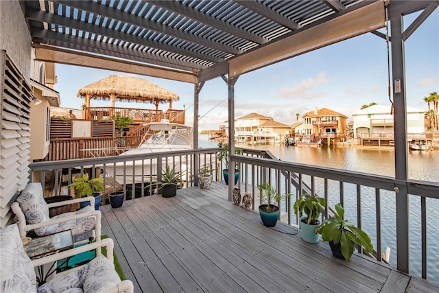 wooden terrace with a water view, a gazebo, and a pergola