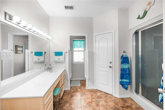 bathroom featuring an enclosed shower, vanity, and tile patterned flooring