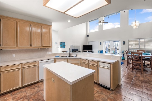 kitchen featuring a high ceiling, ceiling fan with notable chandelier, dishwasher, and a center island