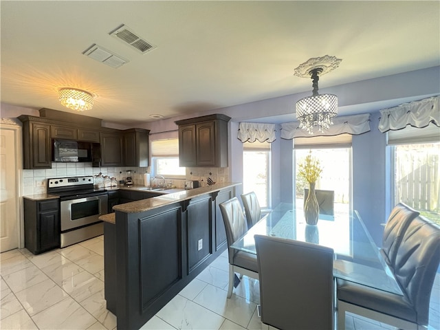 6317 Sir Jack St, Corpus Christi, TX 78414 - kitchen featuring stainless steel electric range, black microwave, a chandelier, a peninsula, and light marble finish floors