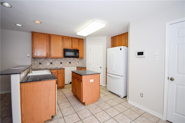 14435 Compass St Unit C, Corpus Christi, TX 78418 - kitchen with black microwave, freestanding refrigerator, a sink, tasteful backsplash, and dark countertops