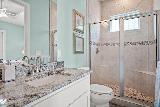 bathroom featuring ceiling fan, vanity, toilet, and an enclosed shower