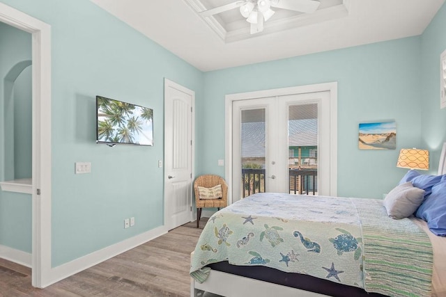 bedroom with light wood-type flooring, access to outside, ceiling fan, and french doors