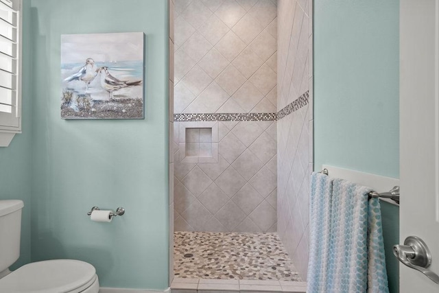 bathroom featuring toilet and tiled shower