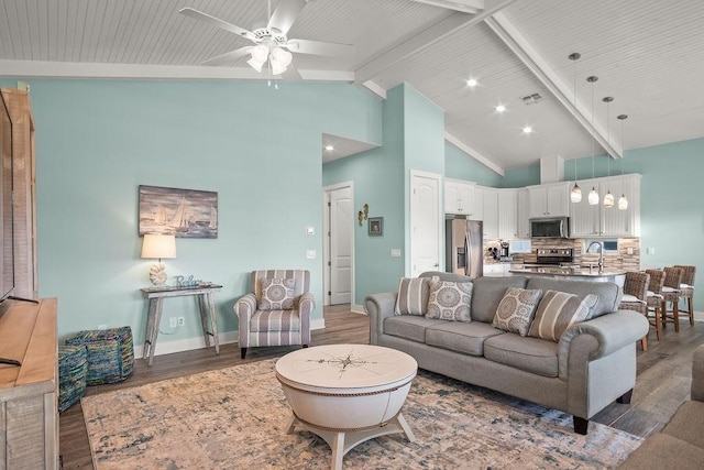 living room with sink, ceiling fan, high vaulted ceiling, dark hardwood / wood-style floors, and beamed ceiling