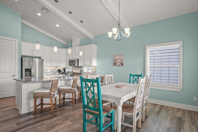 dining room featuring a notable chandelier, dark wood-type flooring, and lofted ceiling with beams