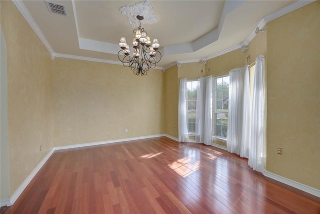 7725 Marissa Dr, Corpus Christi, TX 78414 - unfurnished room with wood finished floors, a chandelier, a raised ceiling, baseboards, and crown molding