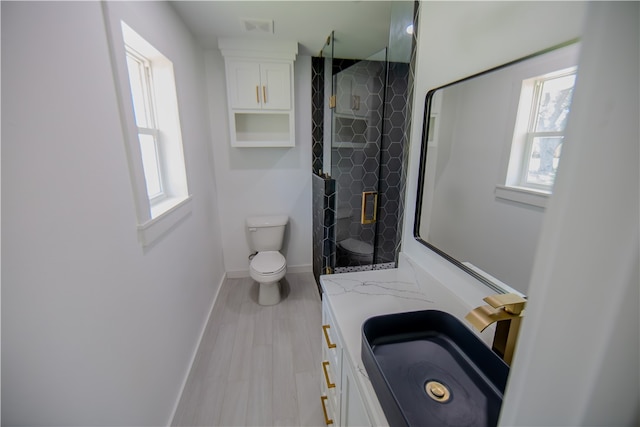 bathroom with an enclosed shower, vanity, hardwood / wood-style flooring, and toilet