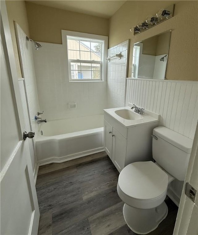 full bathroom with vanity, hardwood / wood-style floors, tiled shower / bath, and toilet