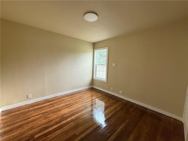 spare room with dark wood-type flooring