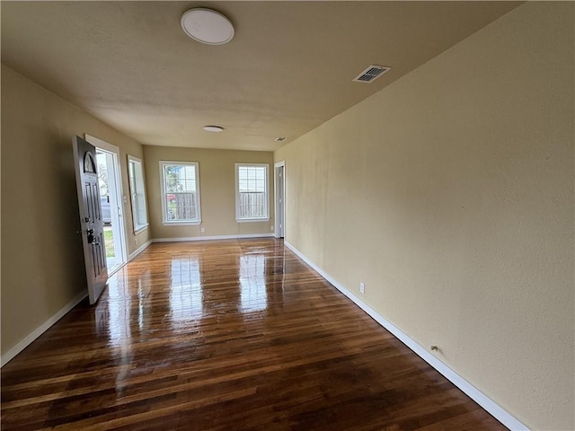 unfurnished room with dark wood-type flooring